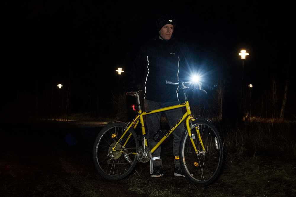 Cykelregler och säkerhet En man i mörkret och en cykel med en cykellampa. Lär dig mer om cykelregler.